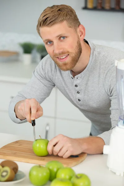 Junger Mann Schneidet Äpfel Und Bereitet Apfelsaft — Stockfoto