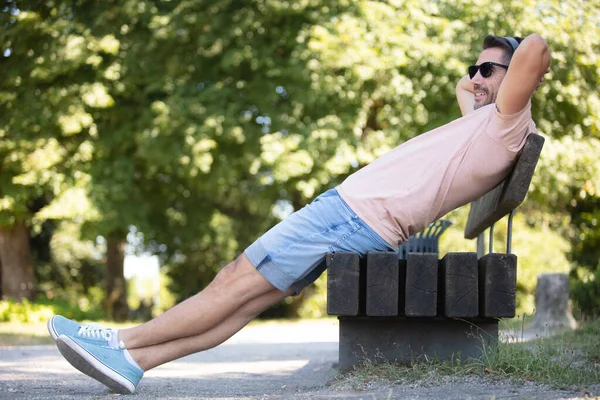 Schöner Mann Sitzt Auf Parkbank — Stockfoto