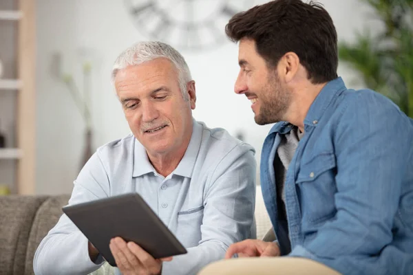 Senior Benutzt Tablet Mit Seinem Erwachsenen Sohn — Stockfoto