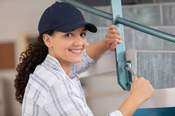 Feminino Contratante Reparos Escada Metal Com Uma Chave — Fotografia de Stock