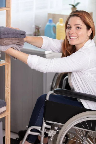 Woman Wheelchair Tidying Towels — Stock Photo, Image