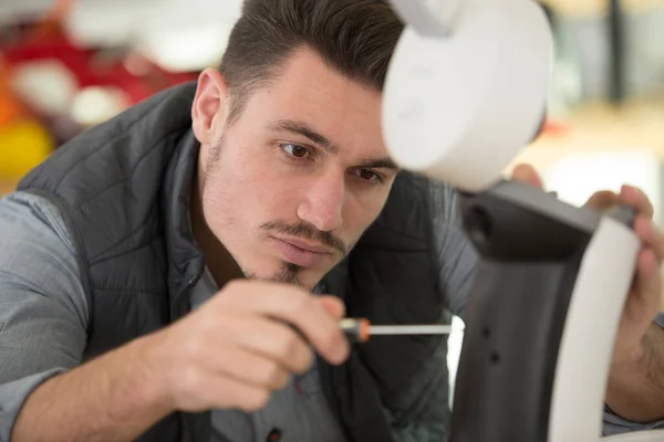 serious man repairing broken coffee machine