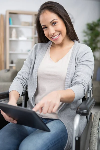 轮椅上使用平板电脑的休闲女性肖像 — 图库照片