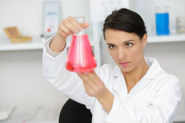 Cientista Fêmea Examinando Líquido Vermelho Frasco Vidro — Fotografia de Stock