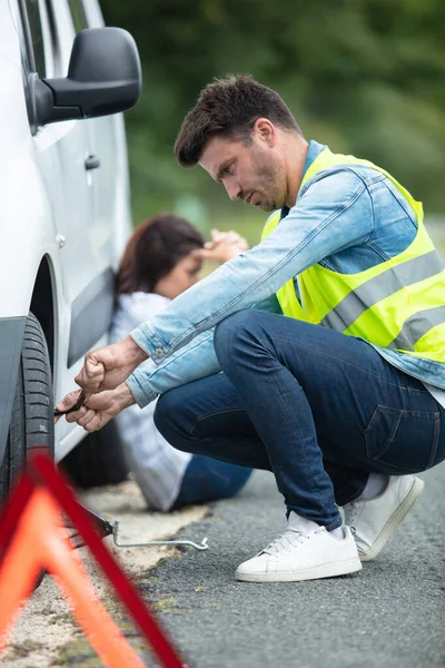 Hombre Repara Neumático Pinchado Mientras Mujer Deprimida Espera — Foto de Stock