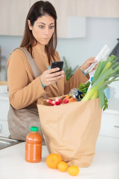 Kvinna Kontrollerar Ett Långt Matkvitto — Stockfoto