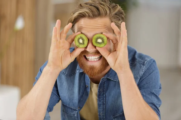 Mann Hält Zwei Aufgeschnittene Kiwis Den Augen — Stockfoto