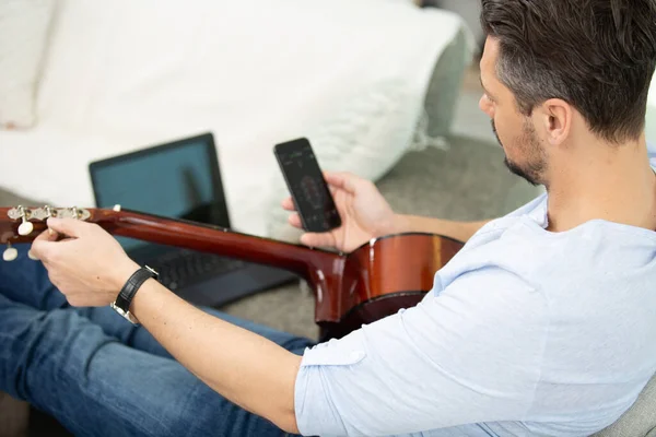 Man Med Gitarr Och Surfplatta Sittande Vid Bordet — Stockfoto