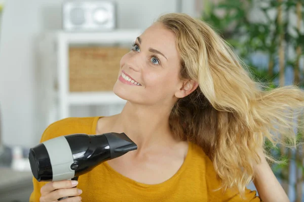 Junge Frau Trocknet Ihre Haare Mit Einem Elektrischen Föhn — Stockfoto