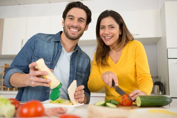 家庭のキッチンでハンバーガーを食べるカップルの写真 — ストック写真