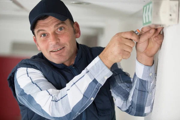 Man Fixing Exit Sign Wall — Stock Photo, Image