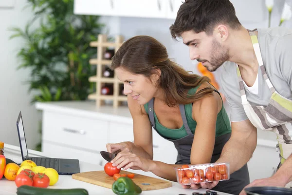 若いカップルは食べ物を準備してノートパソコンでレシピを — ストック写真