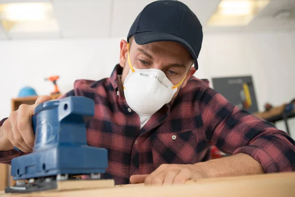 Człowiek Pracuje Masce Bezpieczeństwa Podczas Szlifowania Drewna — Zdjęcie stockowe