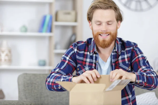 Sorrindo Curioso Homem Abrindo Sua Caixa Papelão — Fotografia de Stock