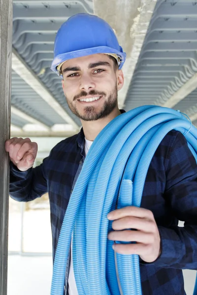 Eletricista Feliz Está Segurando Tubos — Fotografia de Stock
