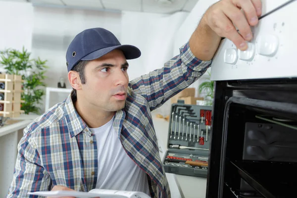 Bonito Jovem Reparador Fixação Forno Com Chave Fenda — Fotografia de Stock