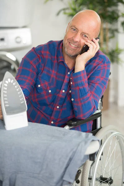 Gelukkige Gehandicapte Man Aan Telefoon Strijken Kleding — Stockfoto