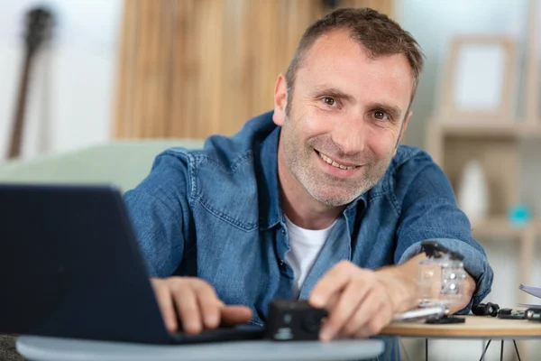 Gülümseyen Adam Masada Dizüstü Bilgisayar Kullanarak Oturuyor — Stok fotoğraf