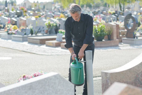 Mann Füllt Gießkanne Aus Wasserhahn Auf Friedhof — Stockfoto