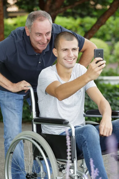 Figlio Handicappato Sulla Sedia Rotelle Prendendo Selfie Con Papà — Foto Stock