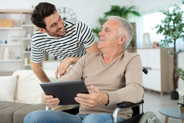 Ein Erwachsener Sohn Mit Einem Älteren Vater Rollstuhl Hause — Stockfoto