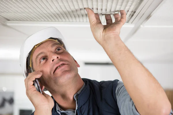 Builder Cell Phone Checking Ceiling State — Stock Photo, Image