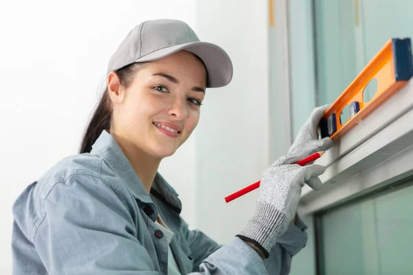 portait of a woman measuring window frame