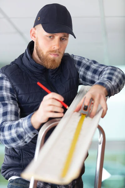 Male Contractor Stepladder Measuring Cornice — Stock Photo, Image