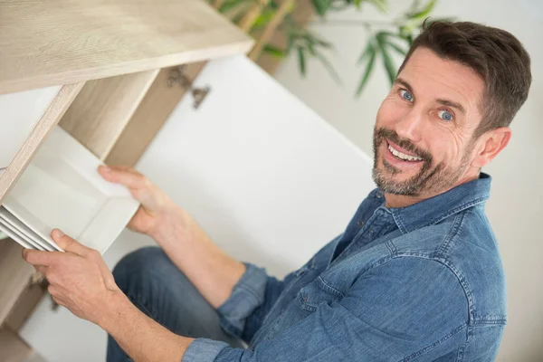 Hombre Alcanzando Placa Ordenada Gabinete Cocina —  Fotos de Stock