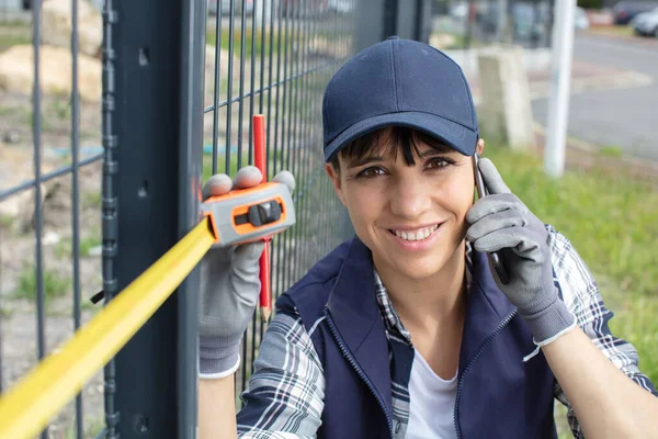 Woman Contractor Measuring Metal Fence — Stock Photo, Image