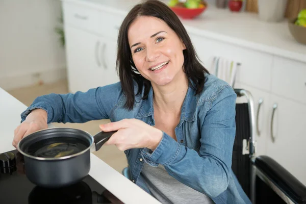 Vrouw Met Een Handicap Plaatst Steelpan Inductie Kookplaat — Stockfoto