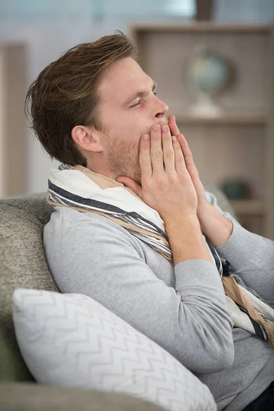 Mann Auf Sofa Bedeckt Seinen Mund Während Gähnt — Stockfoto