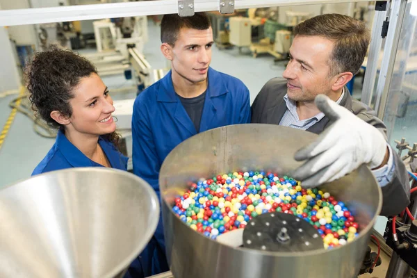 Worker Showing Trainees Hopper Full Colorful Beads — Stock Photo, Image