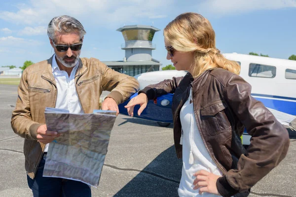 Pareja Cerca Avión Privado Aeropuertobuscando Mapa —  Fotos de Stock