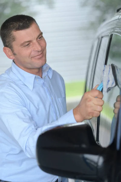 Hombre Sonriente Limpiando Ventana Del Coche —  Fotos de Stock