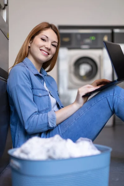 Çamaşırhanede Dizüstü Bilgisayarı Olan Mutlu Genç Bir Kadının Portresi — Stok fotoğraf