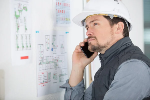 Arbeiter Begutachtet Die Zeichnung Und Spricht Mit Dem Handy — Stockfoto