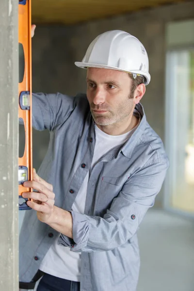 Trabajador Profesional Casco Mide Pared Con Nivel —  Fotos de Stock