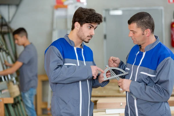 Due Operai Che Parlano Mentre Tengono Mano Righello — Foto Stock