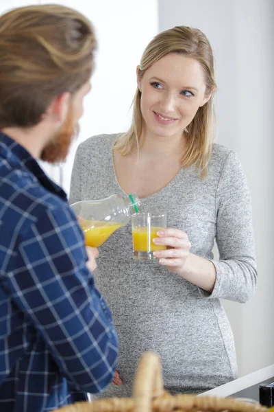 Беременная Женщина Наливает Апельсиновый Сок Стакан — стоковое фото
