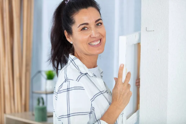 Meisje Opknoping Een Frame Een Muur — Stockfoto