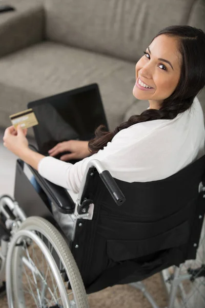 車椅子の女性がラップトップでオンラインで購入し — ストック写真