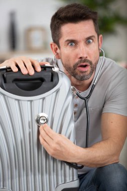 a man using a stethoscope on a suitcase clipart