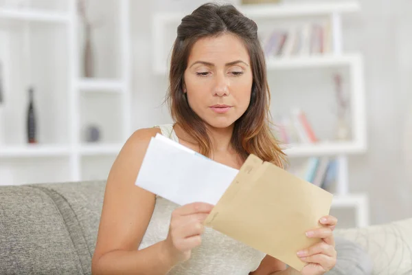 nervous woman taking letter from envelope