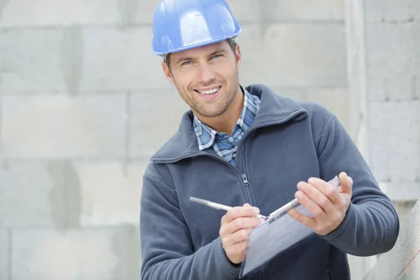 Gutaussehender Bauunternehmer Schreibt Etwas Klemmbrett — Stockfoto