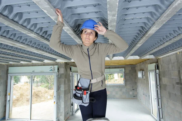 检查屋顶内部的女建筑工人 — 图库照片