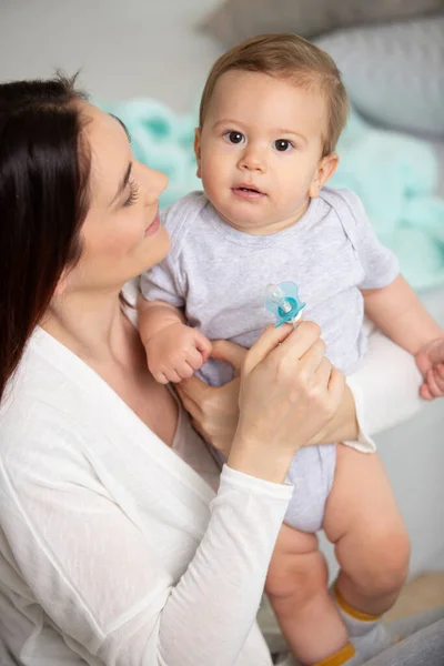 若い幸せな母親が赤ちゃんを抱えて — ストック写真