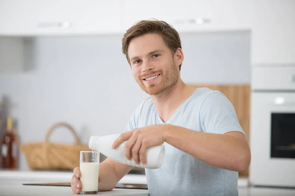 Feliz Joven Sonriendo Mientras Vierte Leche Vaso — Foto de Stock