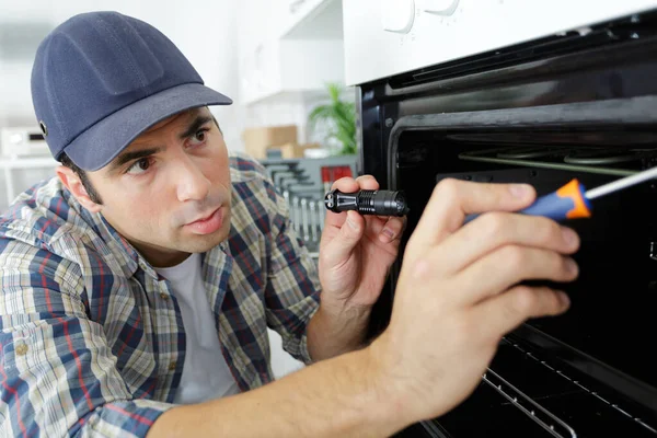 マイクロ波オーブンを修理する男 — ストック写真