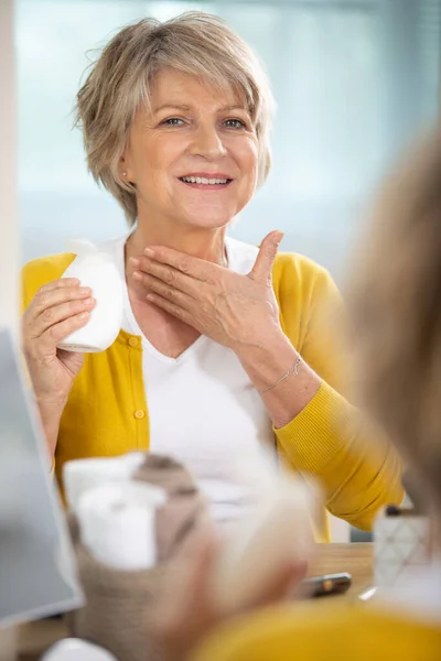 Senior Vrouw Aanbrengen Vochtinbrengende Crème Aan Haar Nek — Stockfoto